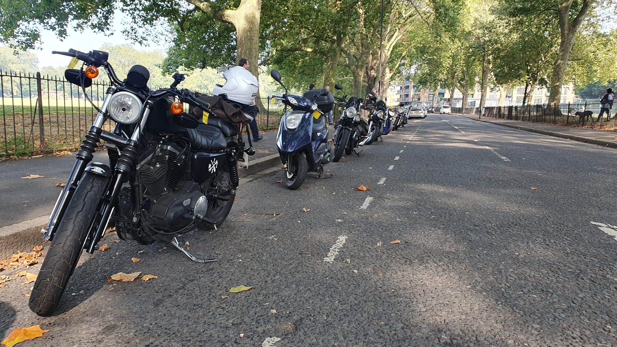 A row of motorbikes are parked parallel to the kerb, instead of perpendicular, so they take up more space. This is part of a protest by Hackney motorbikers.