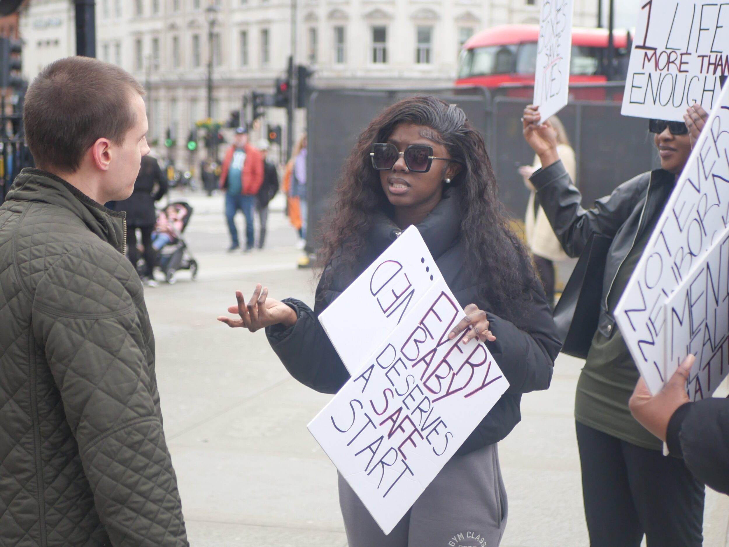 Campaigners on Trafalgar Square with placards calling for the implementation of baby boxes in London. Toyin is leading the chanting at the front.