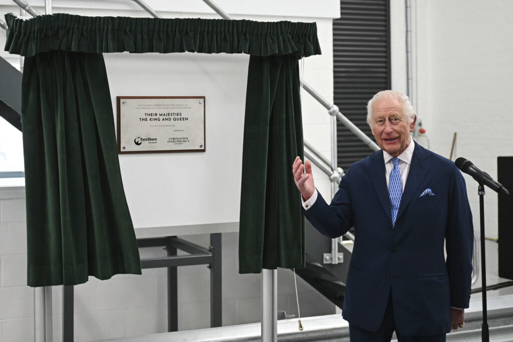 King Charles unveils a plaque as he visits the Coronation Food Project hub