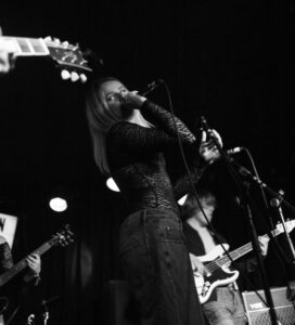 Flo Wilkes performing on stage (black and white)