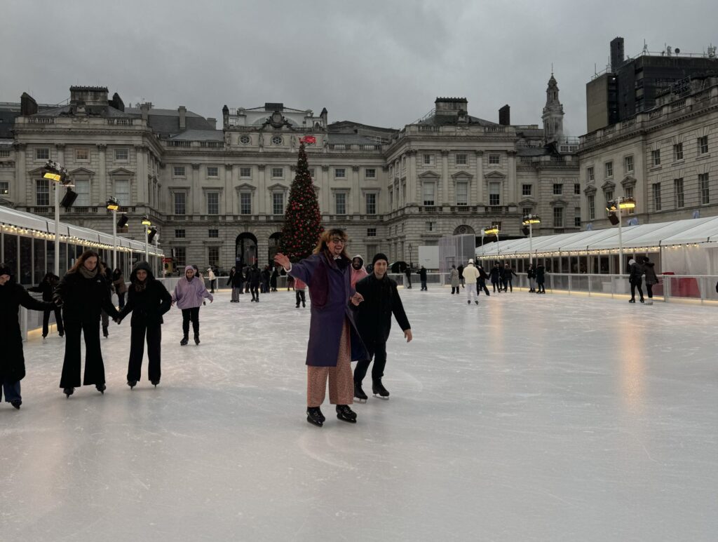 Two skaters on the ice rink at Somerset House, pictured smiling. 