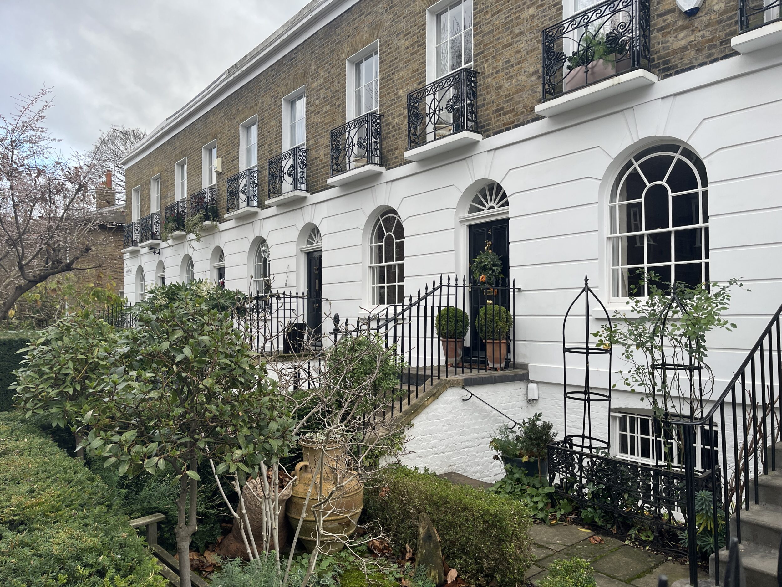 A row of houses with lush green gardens