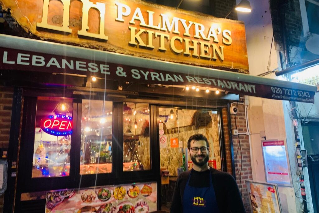 A man stands in front of the Palmyra's Kitchen, a Lebanese and Syrian restaurant in Finsbury Parl.