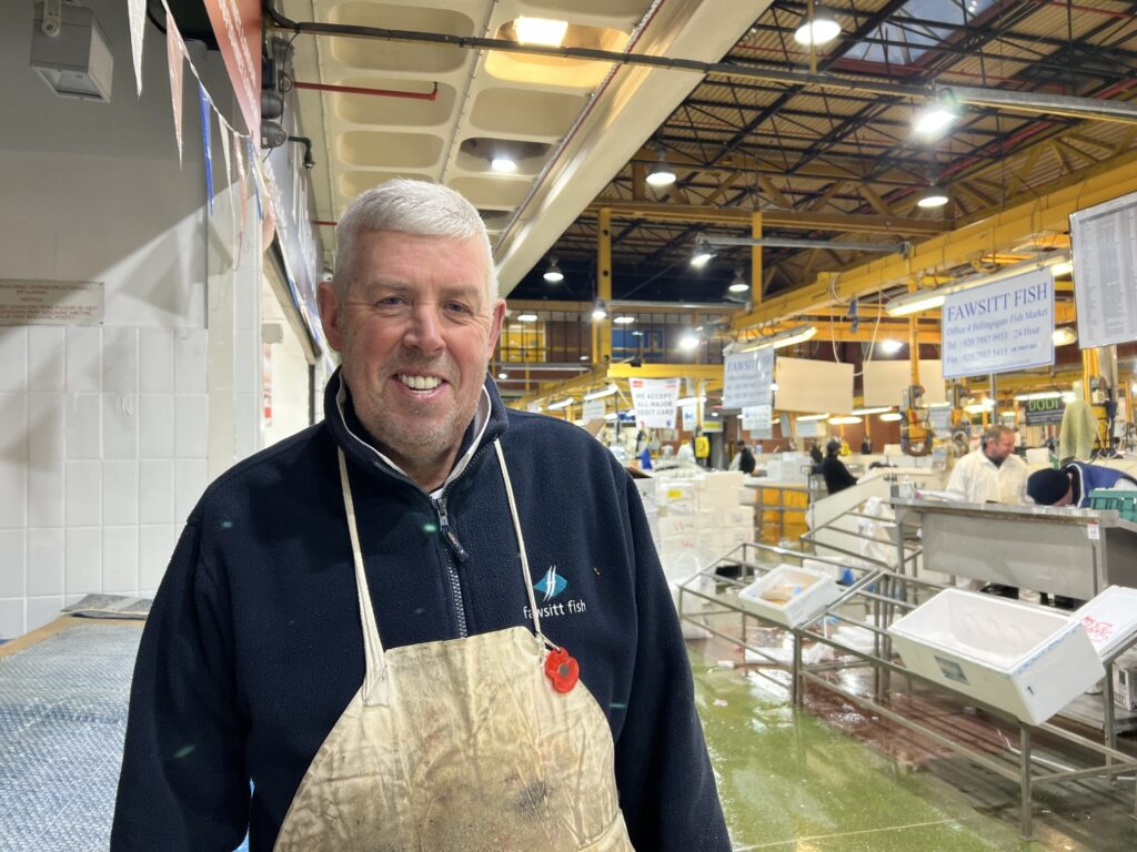 Steven Moore, fish trader stands inside of Billingsgate market.