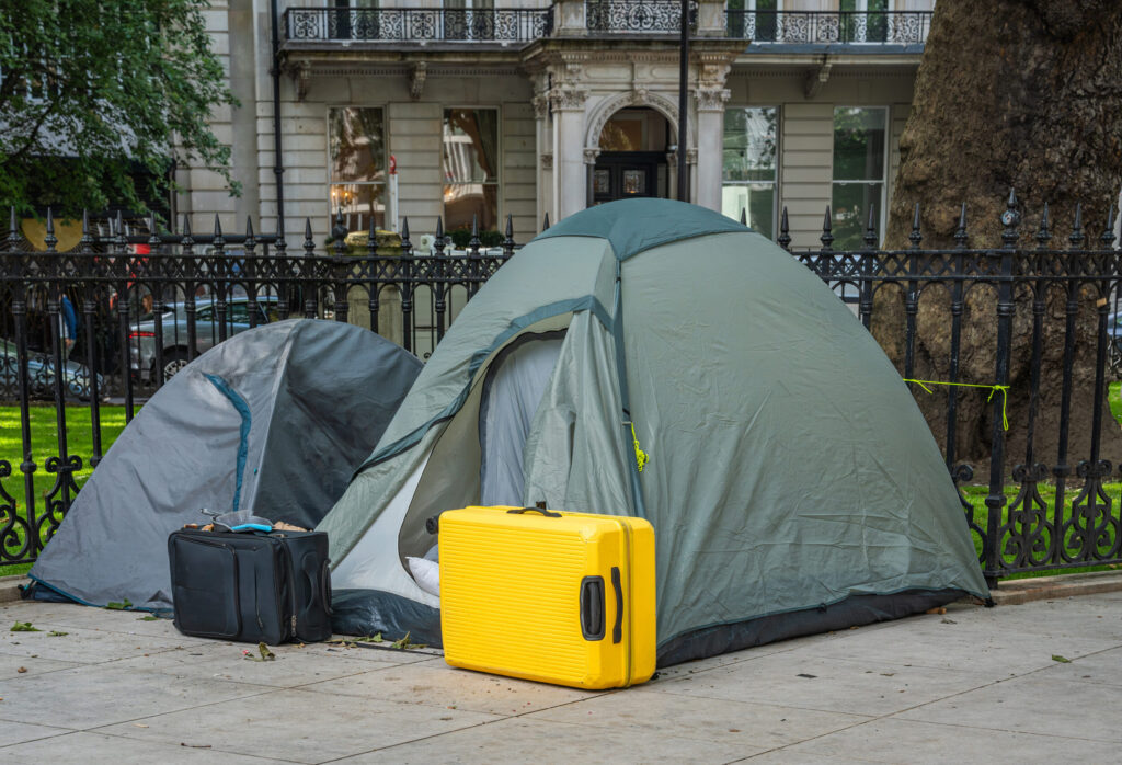 Two tents with suitcases in front of them on a london street