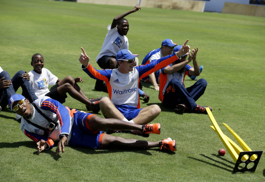 England's cricket players Chris Jordan and Jos Buttler play with kids at the at the Kensington Oval cricket ground in Bridgetown, Barbados, April 29, 2015.