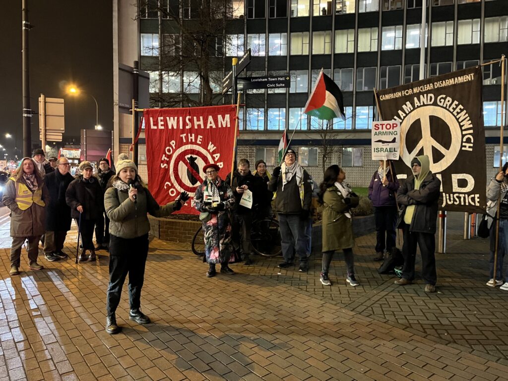 Alia Al Ghussain addresses a crowd holding pro-Palestine signs outside of Lewisham council building.