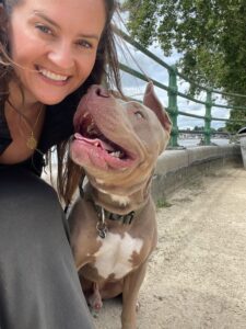 Campaigner Sophie Coulthard is smiling at camera. Her American Bully Billy is looking up at her.