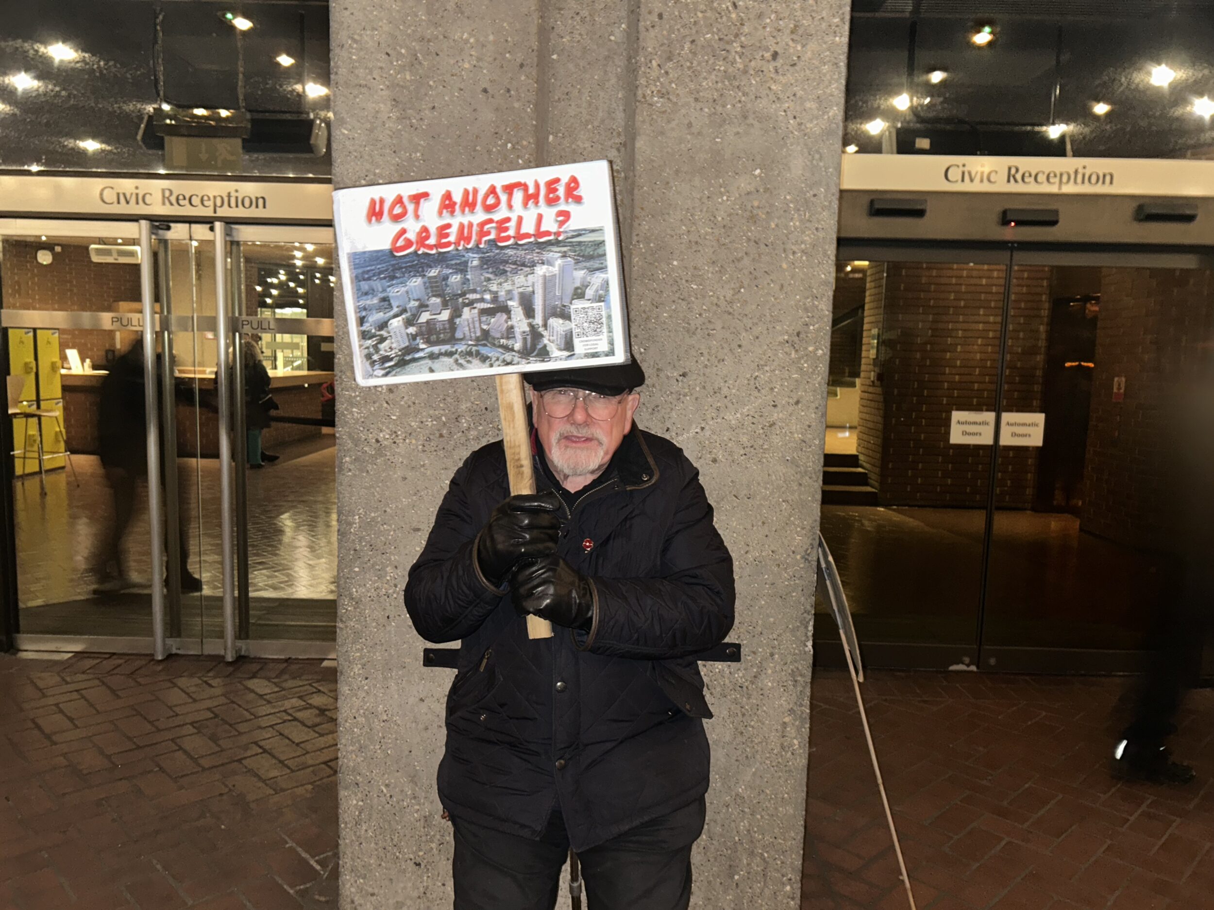 A protestor holds a sign saying "Not another Grenfell"