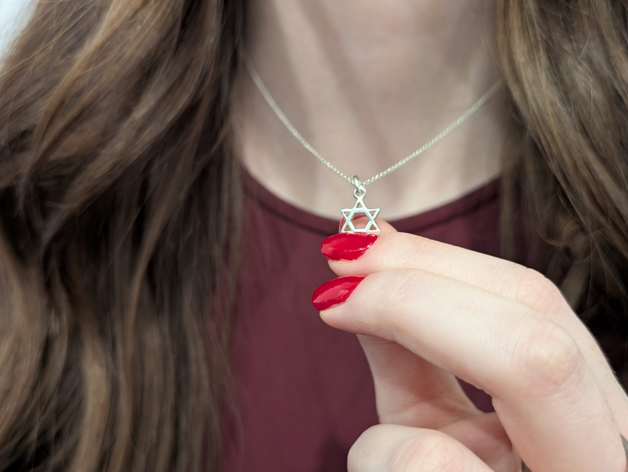 Jewish woman holding Star of David necklace
