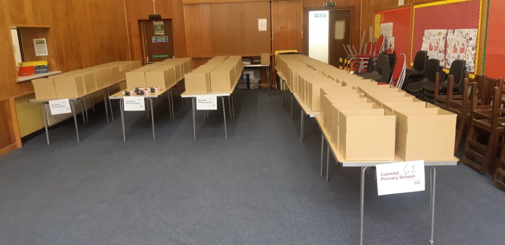 Boxes of meal kits lined up in the community hall, ready for delivery