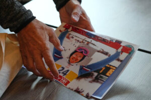 British former ski jumper Michael Edwards, known as Eddie the Eagle, arranges his photos from the 1988 Winter Olympics in Calgary, during an interview at the Ski and Snowboard Center, in Gloucester, England, Wednesday, Nov. 19, 2025. (AP Photo/Frank Augstein)
