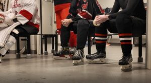 Inside the men's locker room, dressed in their skates