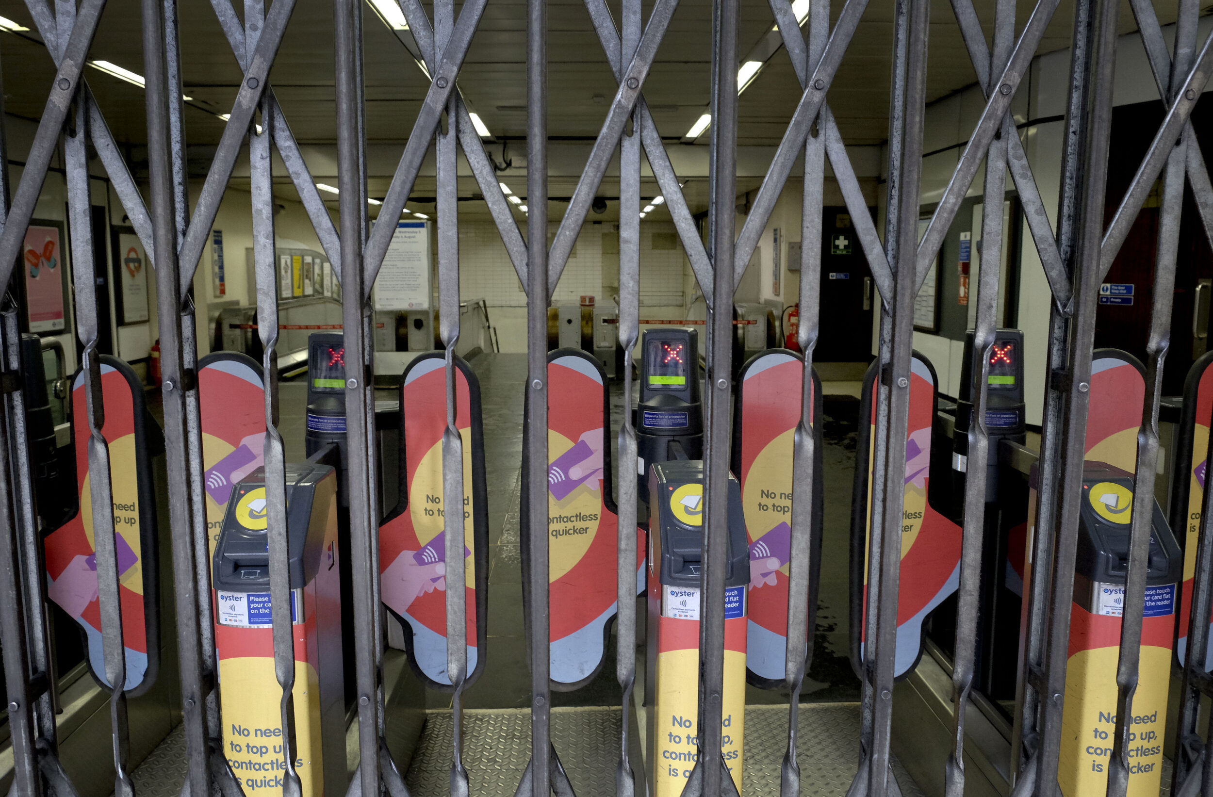 Ticket entrance machines are seen behind metal gates at the closed entrance to Marylebone tube station in London.